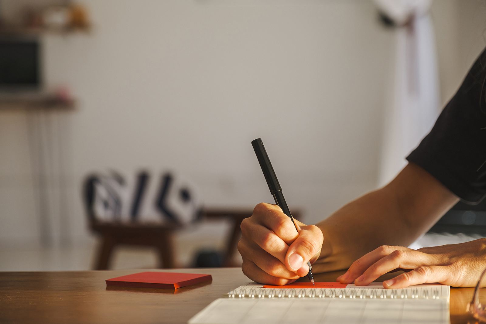 A hand writing a first draft in a notebook